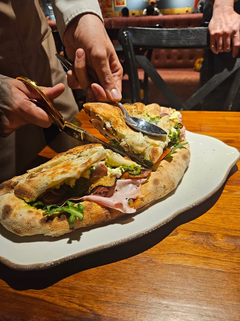 Pizza being cut with scissors — Di Martina artisan style